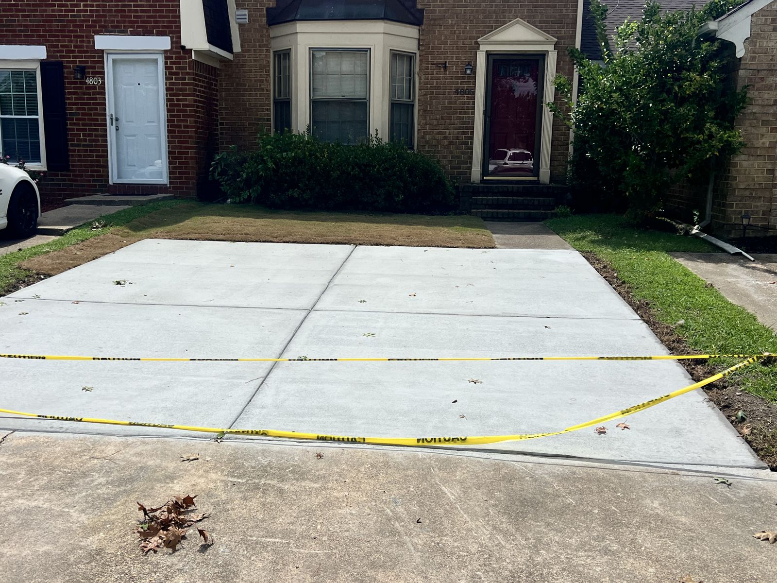 Concrete driveway pad with fresh sod restored along the edges