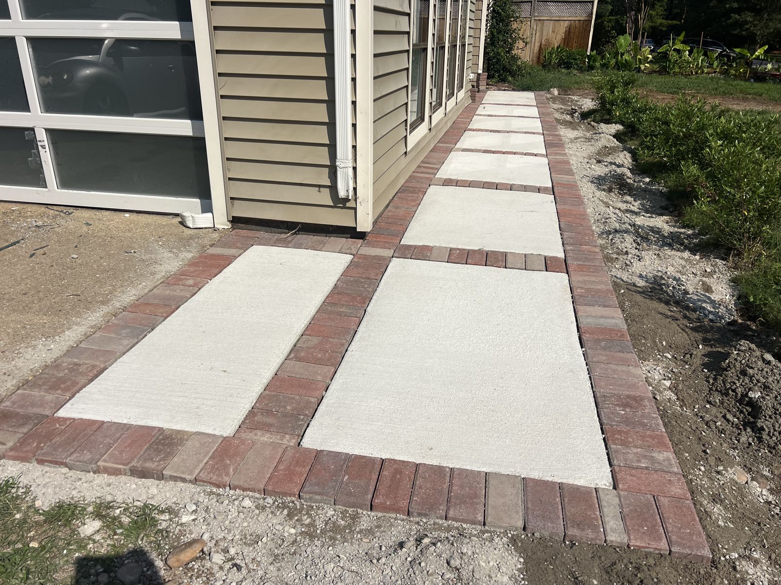 Concrete sidewalk framed with a brick paver border in Virginia Beach
